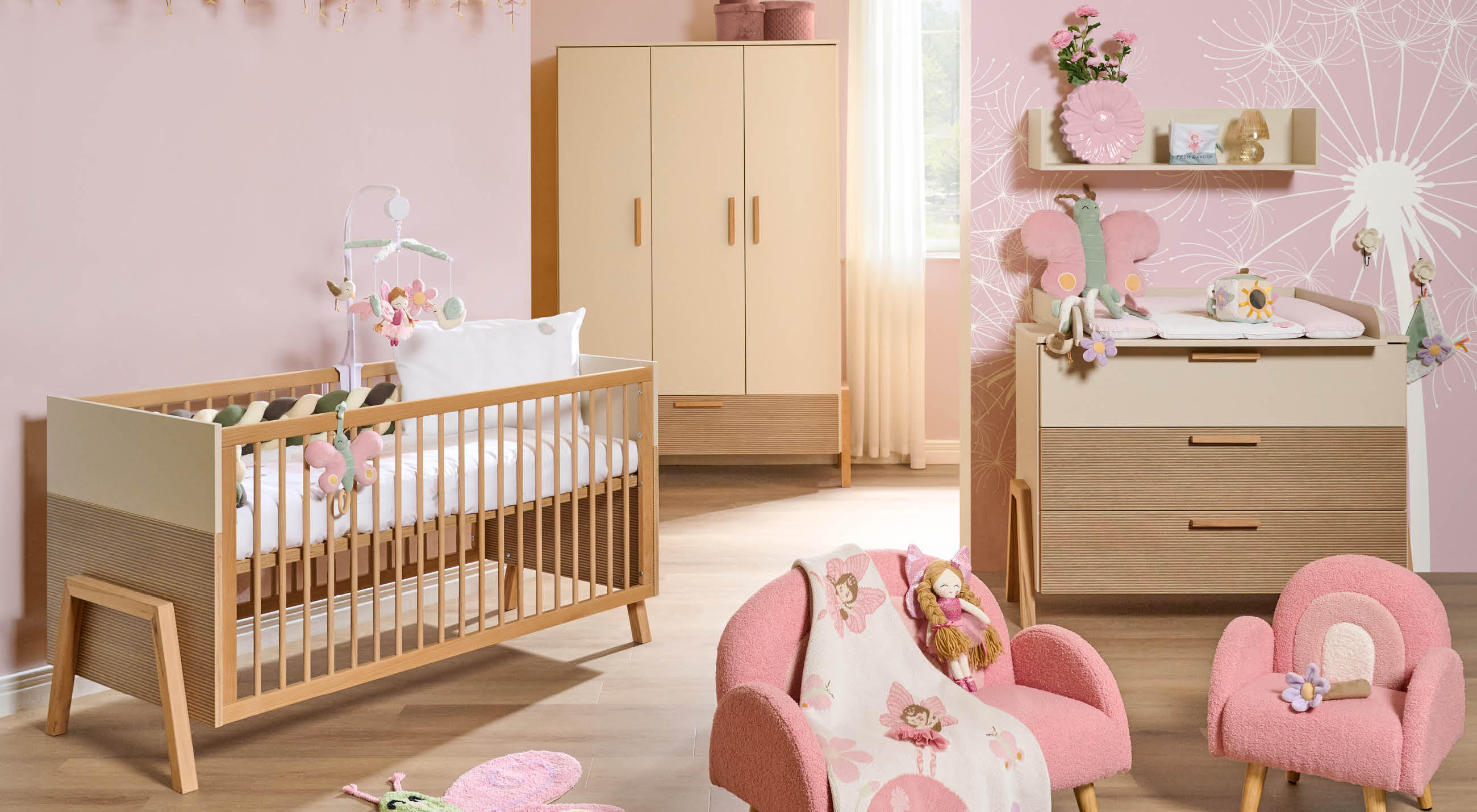 Ein helles Babyzimmer mit rosa Wänden und Möbeln, das eine gemütliche Umgebung für das Baby bietet.