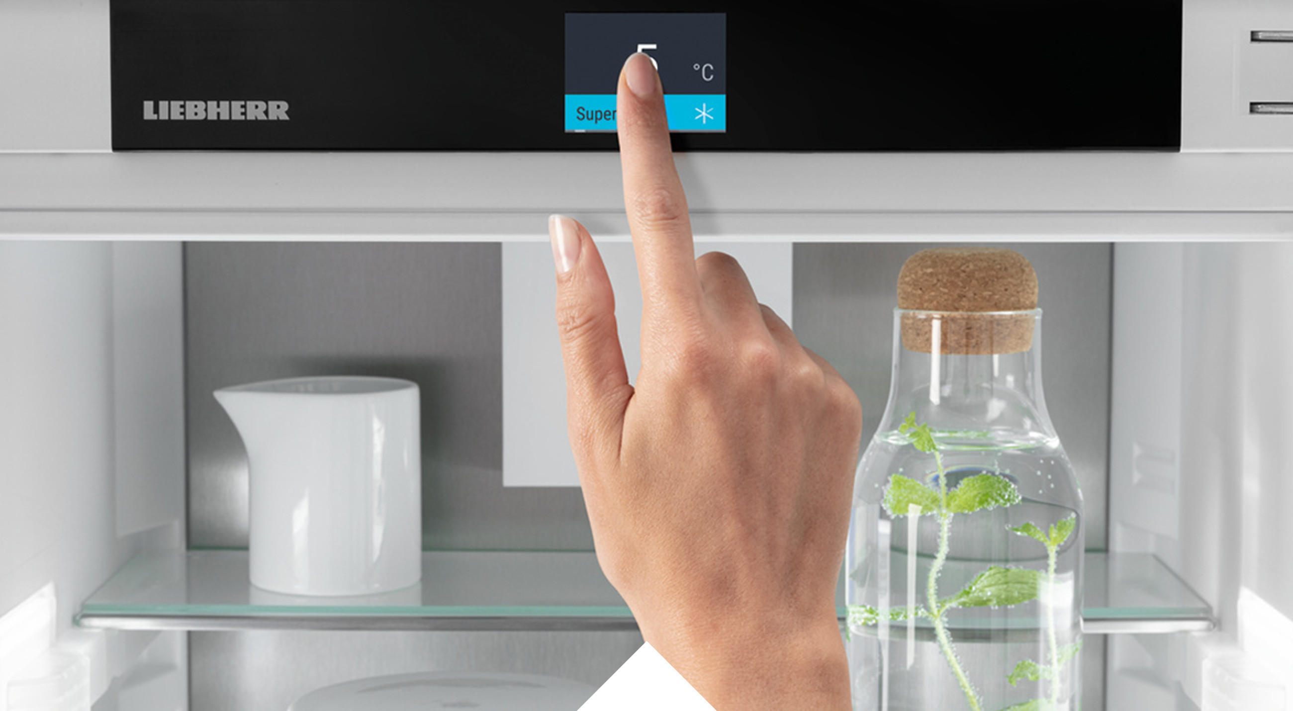 Detailaufnahme einer Hand, die den Touch & Swipe Display von einem LIEBHERR Kühlgerät der Serie PRIME bedient.