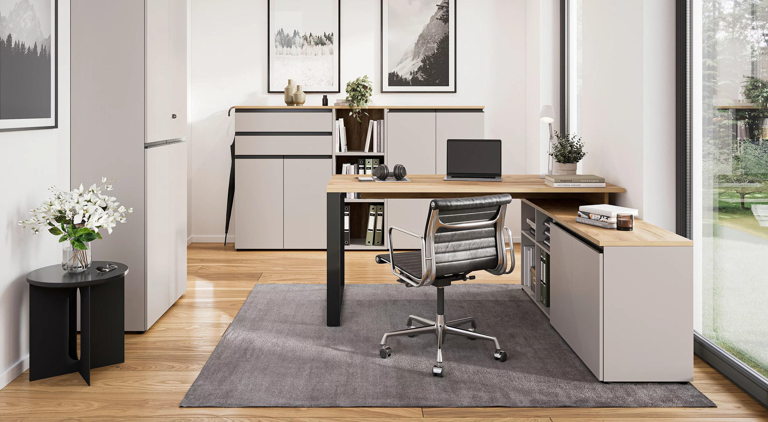 Modernes Arbeitszimmer mit L-förmigem Schreibtisch, Laptop, Büchern und Deko, ergonomischem Stuhl, hellen Wänden, Holzboden und großen Fenstern mit Blick ins Grüne.
