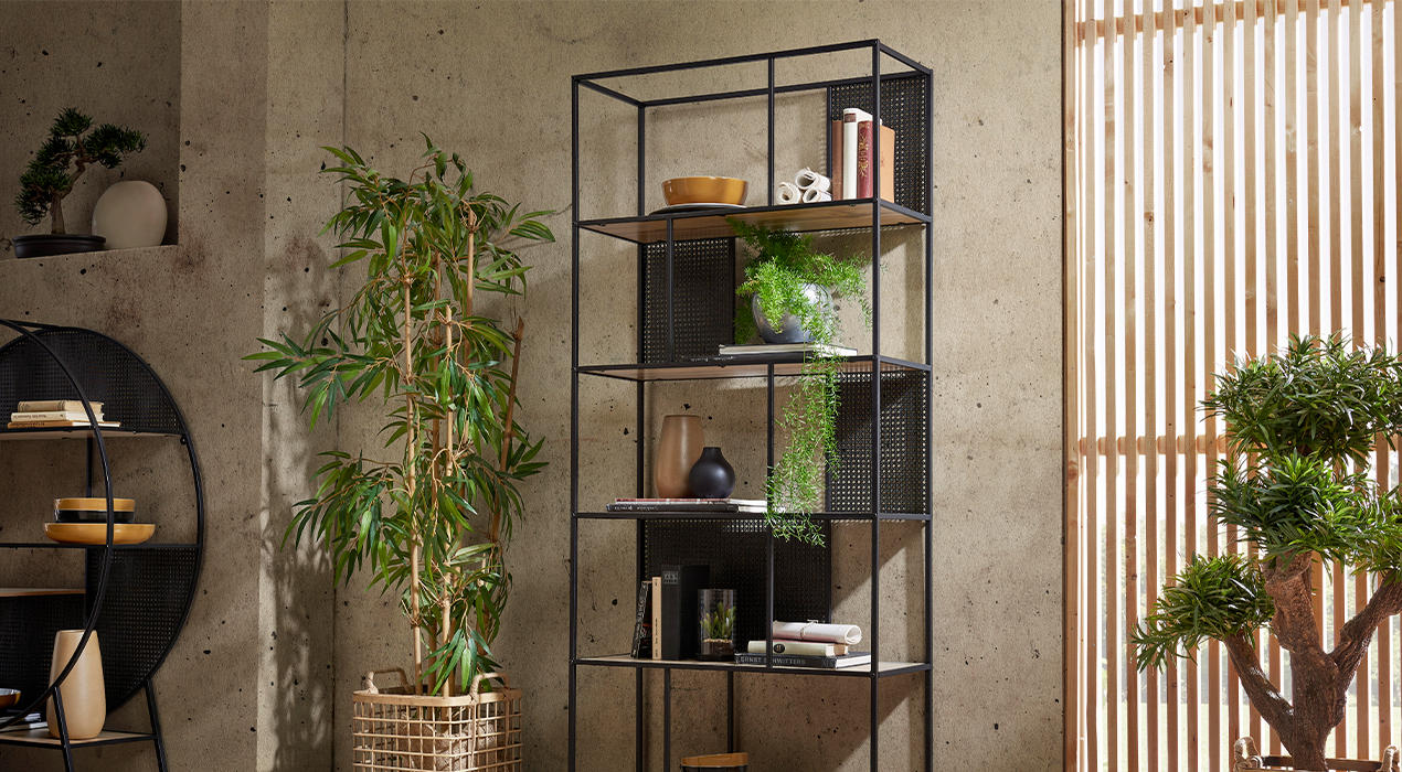 Schwarzes Regal aus Metall mit Holzböden, Accessoires und Pflanzen.