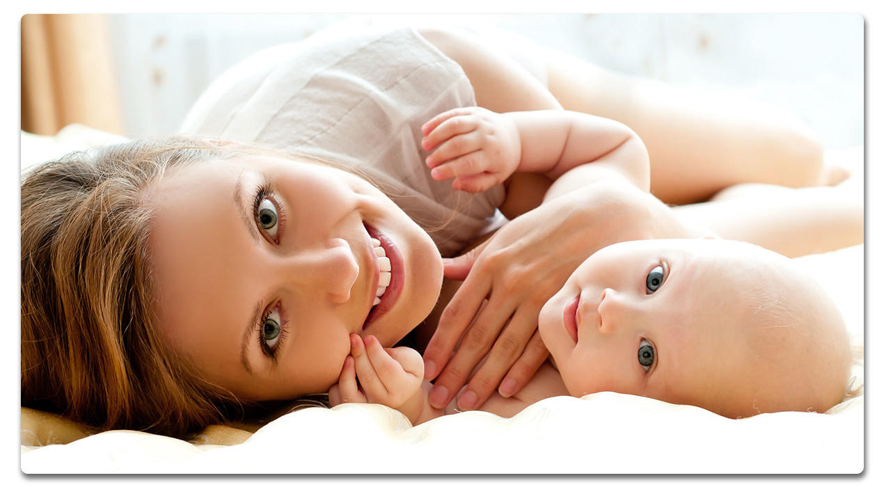 Frau und Baby liegen auf dem bett