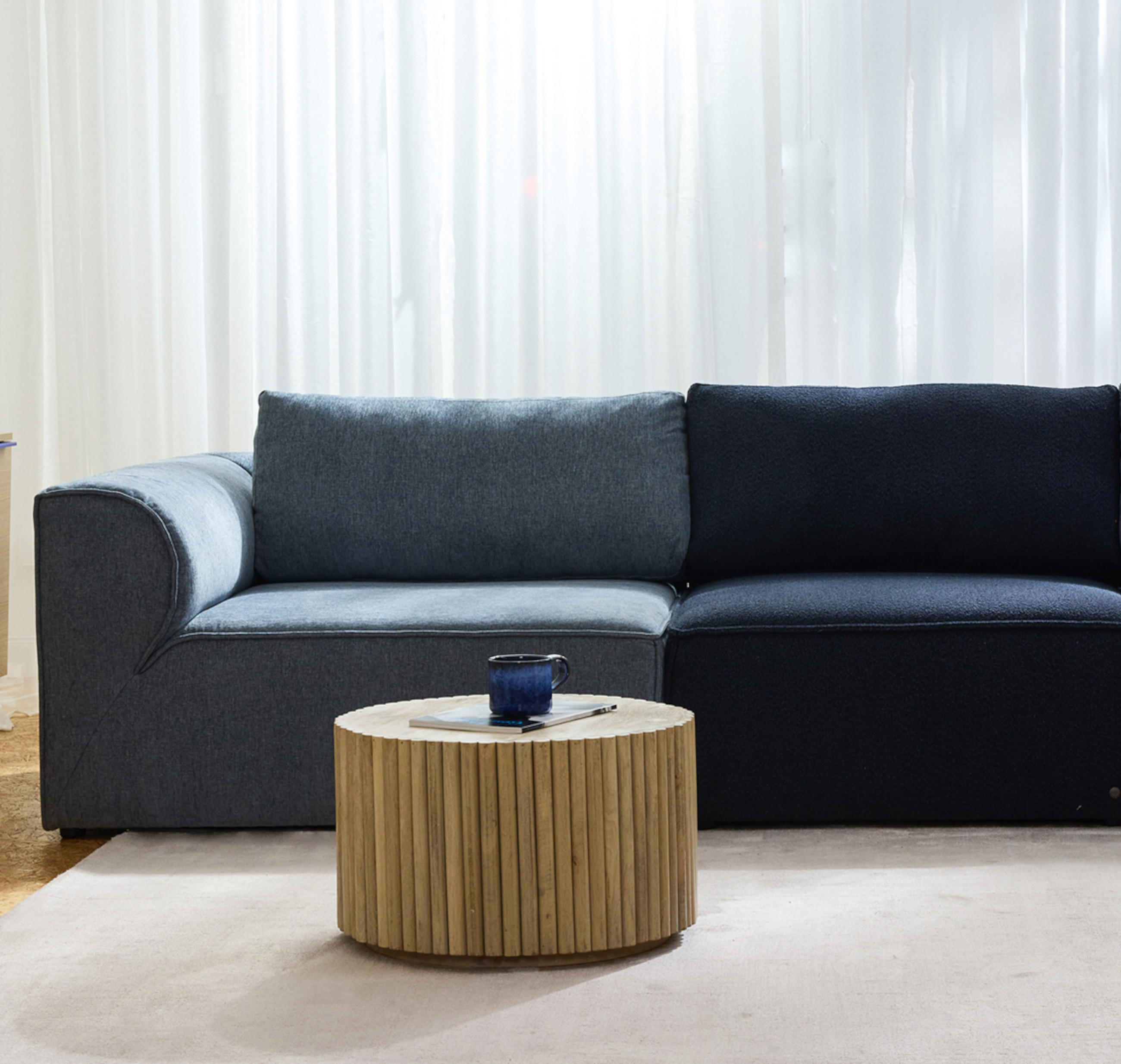 Sofa in dunkel Blau mit einem hell beigen Teppich in einem Wohnzimmer