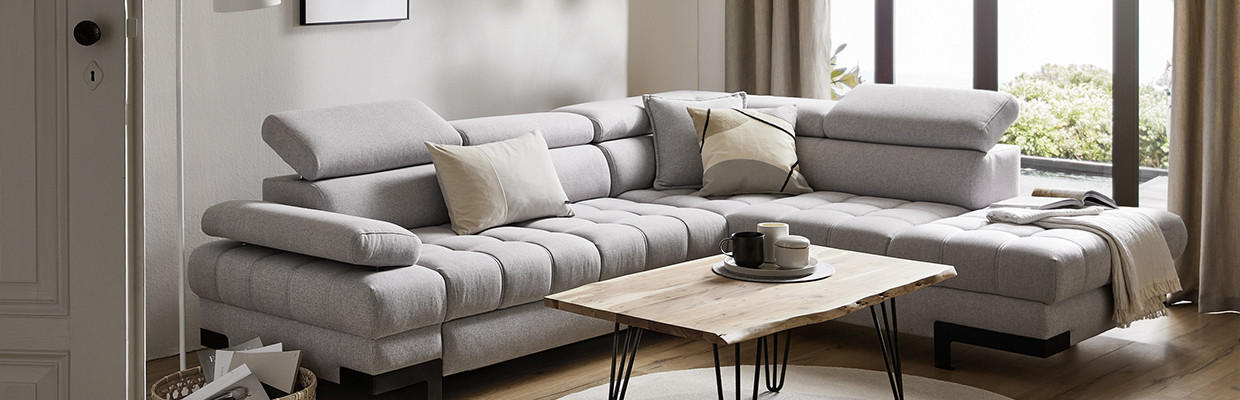 graue couch mit beistelltisch und teppich