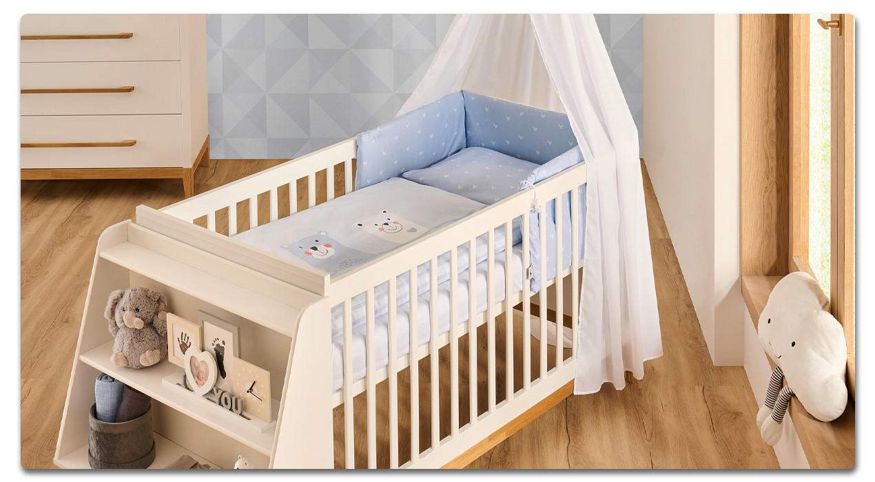weißes Babygitterbett mit blauem Bettwäscheset