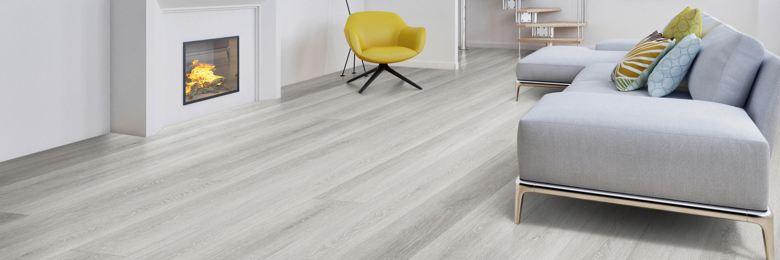 Moderner Wohnraum mit hellgrauem Vinylboden, grauem Sofa mit bunten Kissen, gelbem Sessel und Kamin im Hintergrund