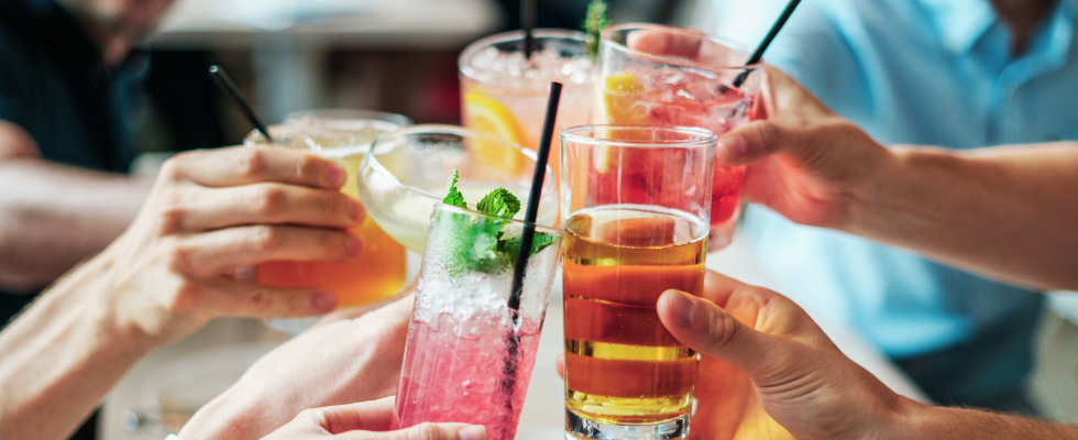 Hände mit Cocktailgläsern
