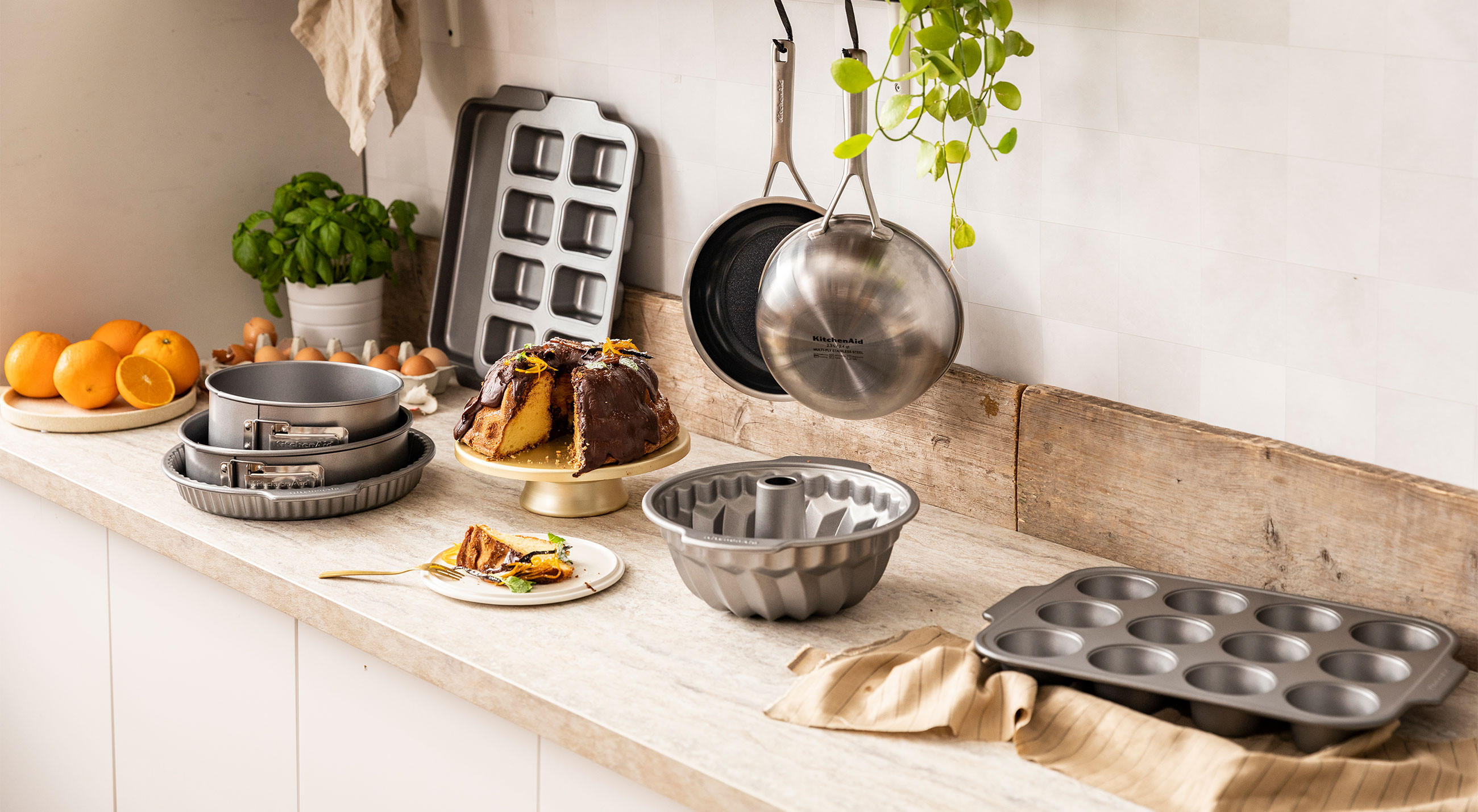 Eine Arbeitsfläche in der Küche, bestückt mit Töpfen, Muffinformen und weiteren Küchenartikeln von KitchenAid.