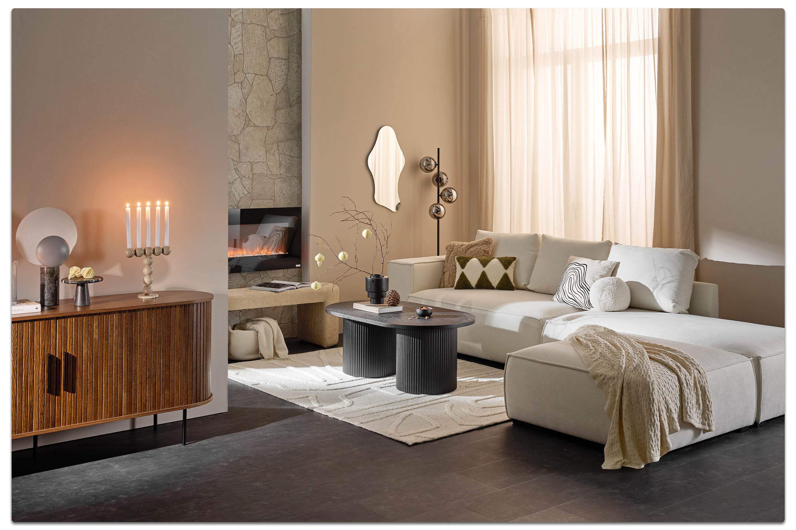 Modernes Wohnzimmer mit hellem Ecksofa, gemusterter Deko, zwei runden Couchtischen, Kamin, Sideboard mit Kerzen und warmen Naturtönen.