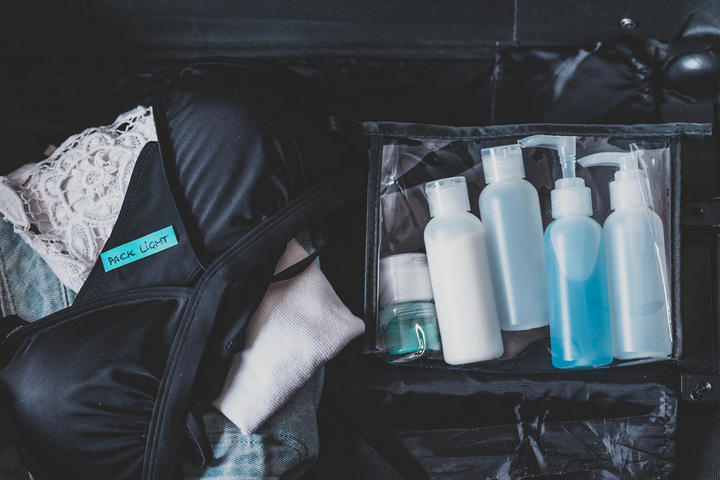 Koffer mit einer Tasche, die Pflegeprodukte für das Handgepäck zeigt, ideal für Reisen.