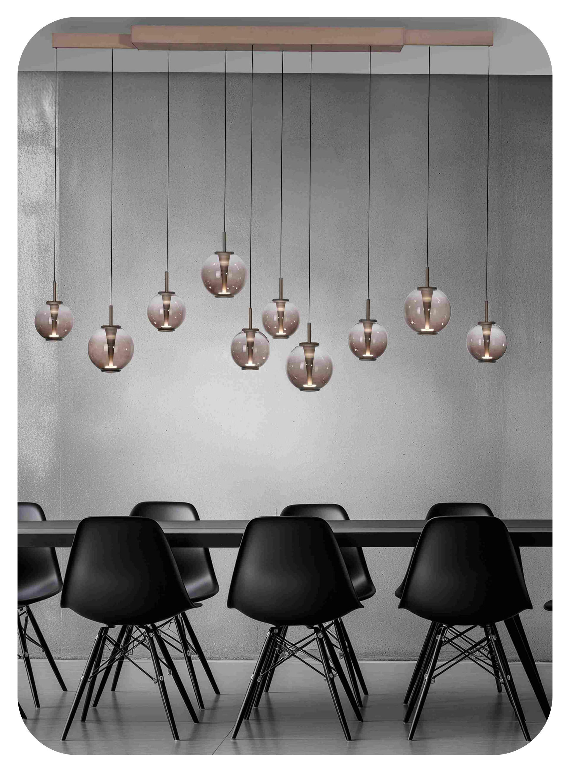 In grau gehaltenes Esszimmer mit schwarzem Esstisch und Stühlen und Hängeleuchte über dem Tisch.