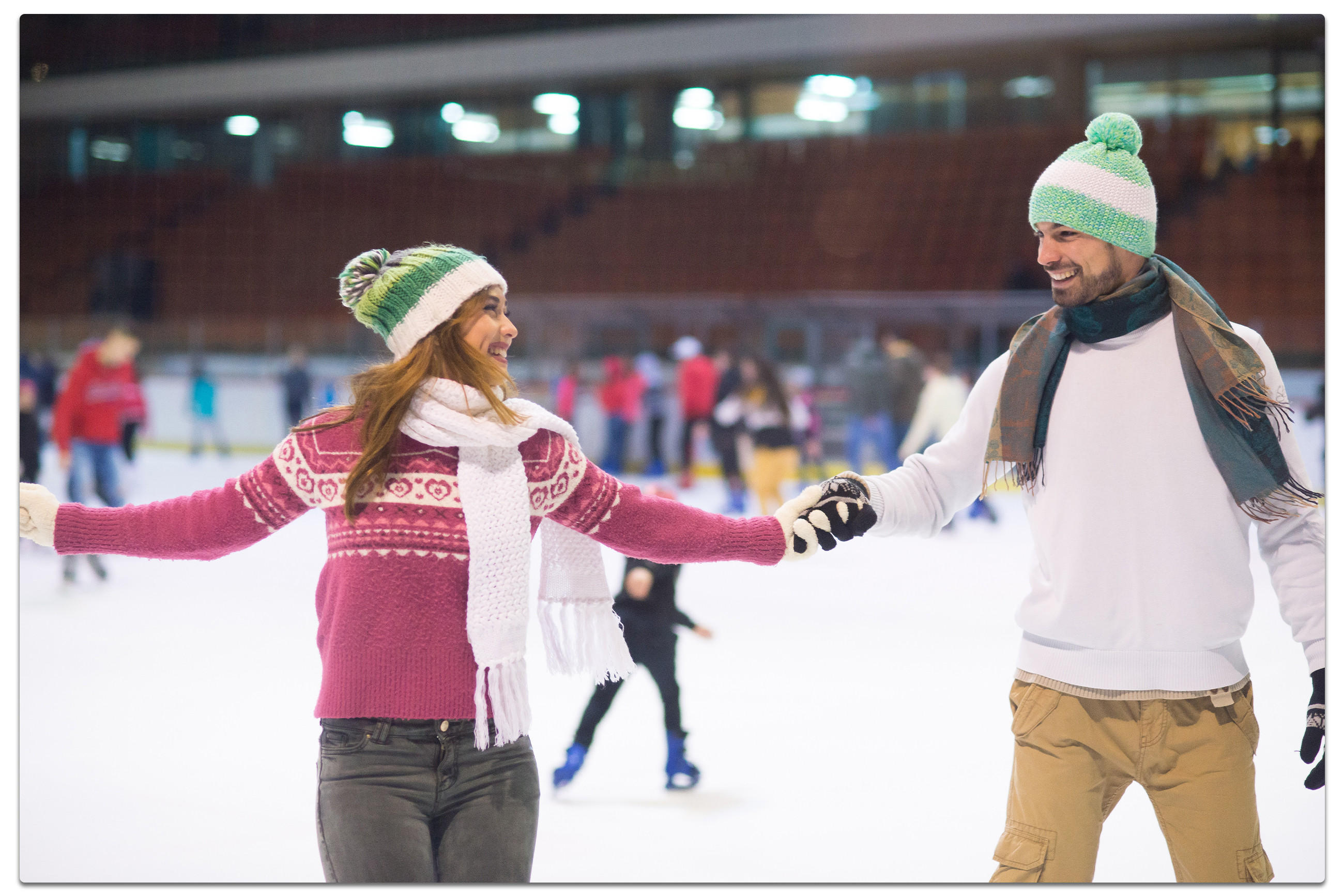 Ein Mann und eine Frau gleiten elegant über eine Eisbahn und genießen das Schlittschuhlaufen.