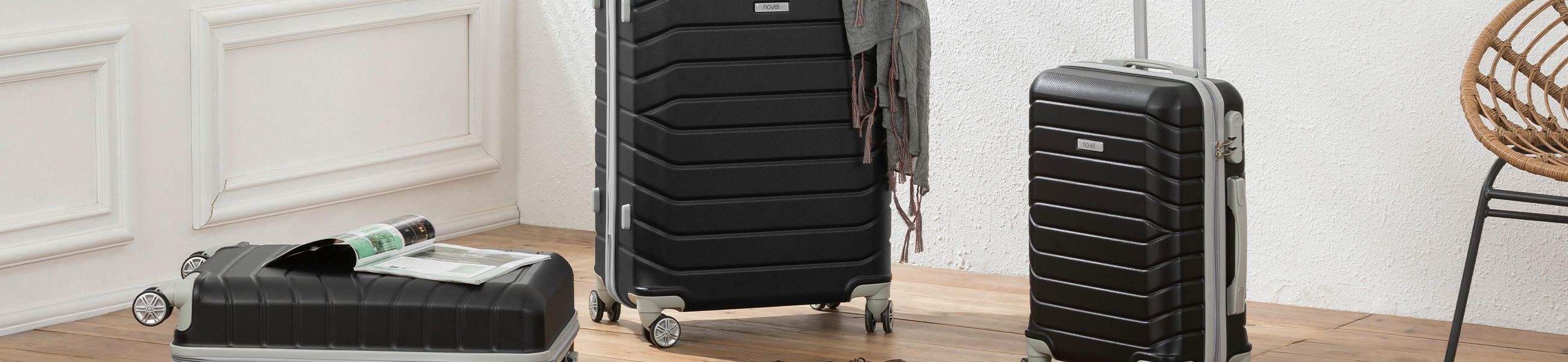 Drei Koffer auf einem Holzfußboden, ideal für Reisen mit Handgepäck.