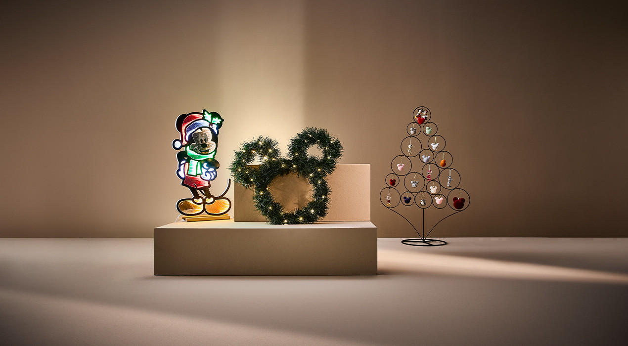 Mickeymouse mit einem Weihnachtsbaum auf einem Podest