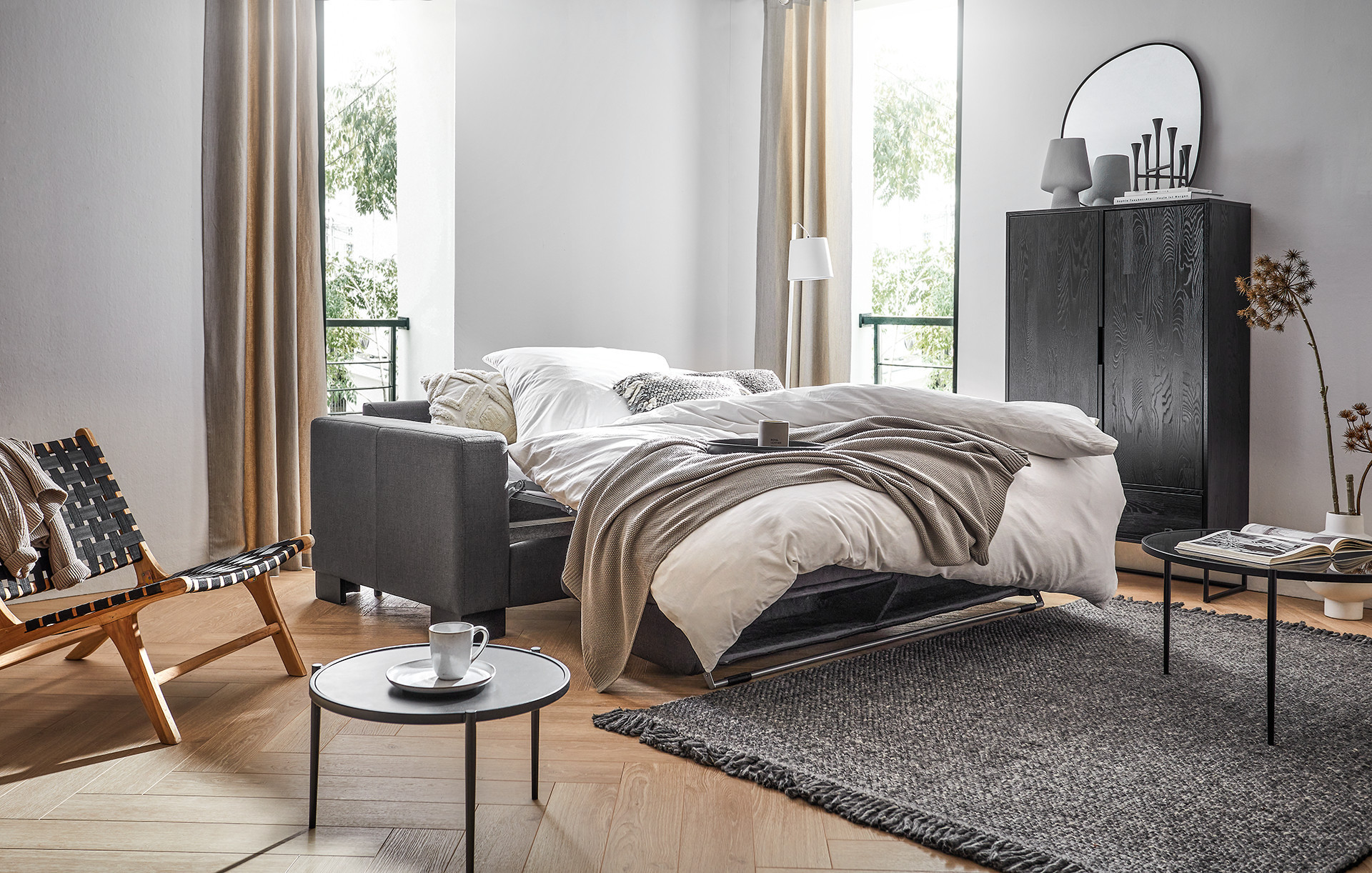 rozkladacia sedačka na každodenné spanie, obývacia izba s rozkladacím gaučom, čierna skrinka, kovový odkladací stolík