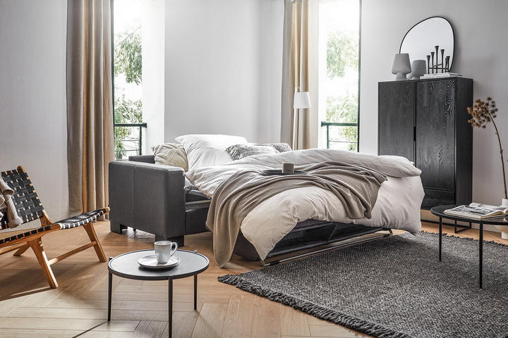 rozkladacia sedačka na každodenné spanie, obývacia izba s rozkladacím gaučom, čierna skrinka, kovový odkladací stolík