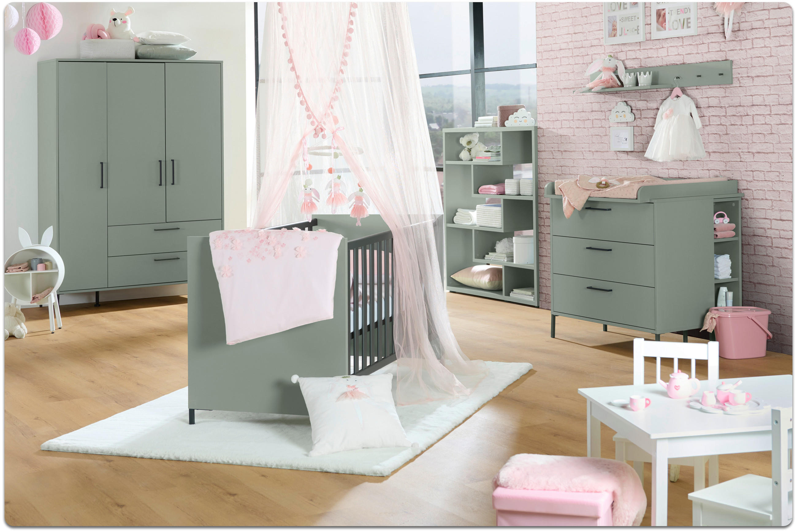 Kinderzimmer mit türkisen Babybett, türkisen Schrank, türkiser Kommode, weißem Teppich, kleinem weißen Tisch mit Stühlen und rosa Dekorationen.
