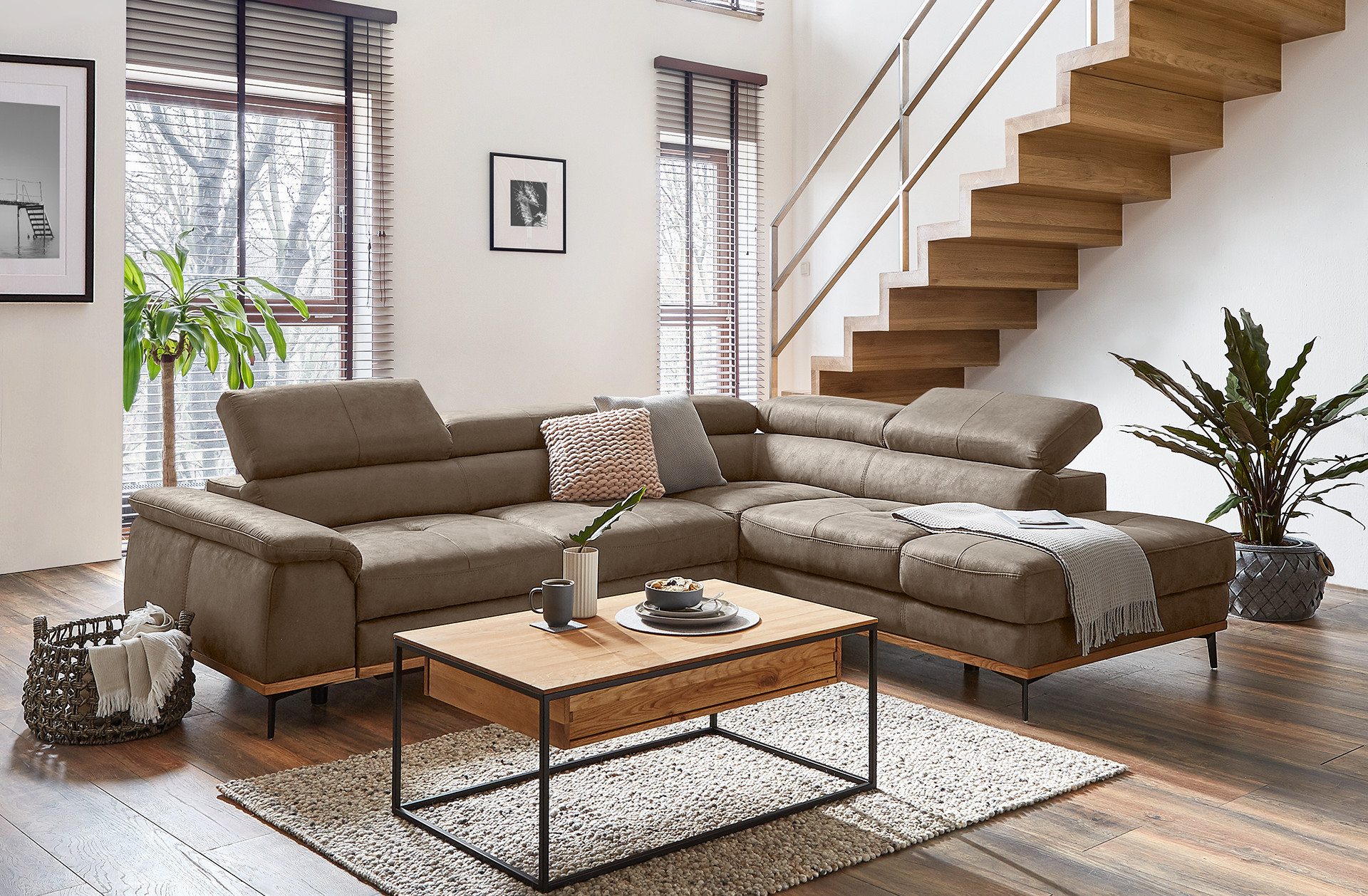 Moderná obývačka s rohovou sedačkou, dreveným stolíkom a útulnými dekoráciami v svetlom interiéri