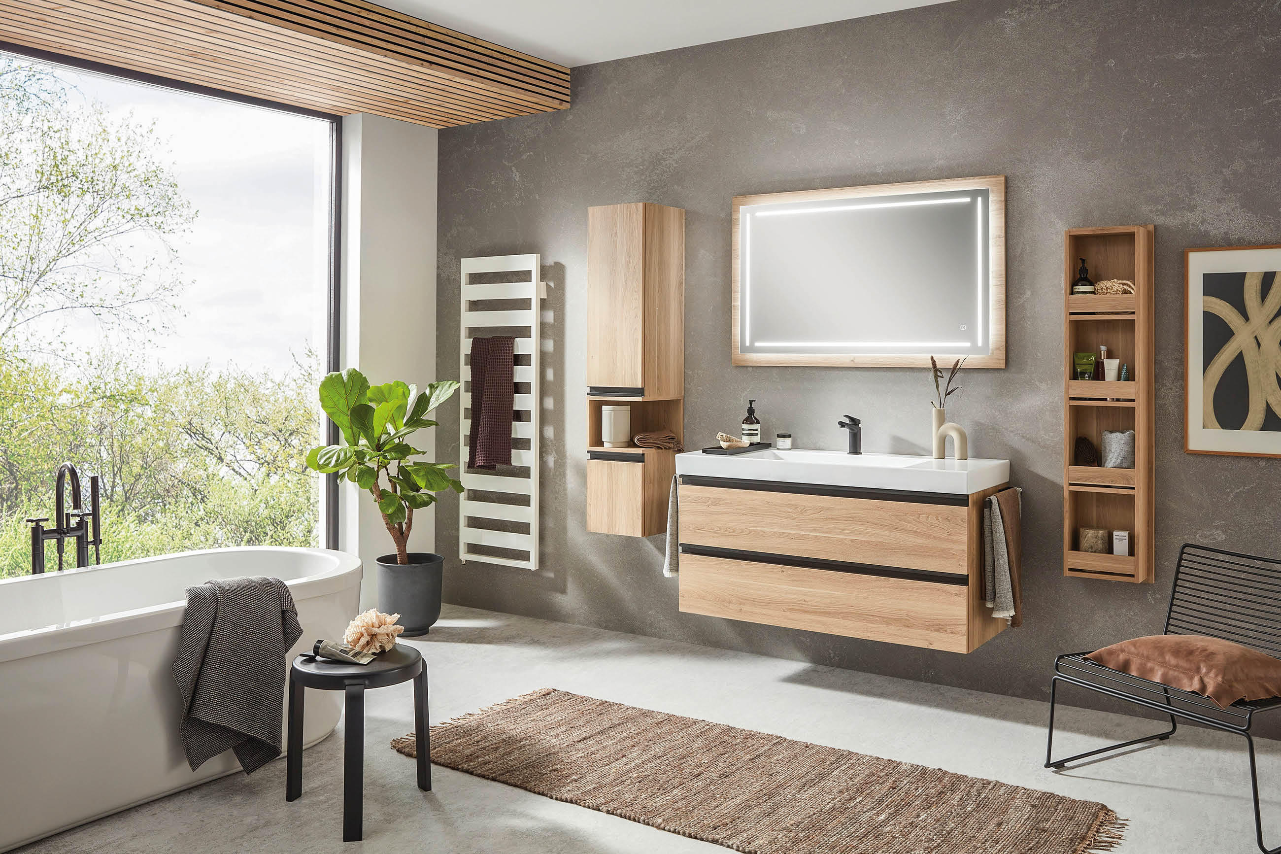 Modernes Badezimmer mit großem Fenster, hängendem Waschbecken mit Holzfront, beleuchtetem Spiegel, Holzschränken und Pflanzen