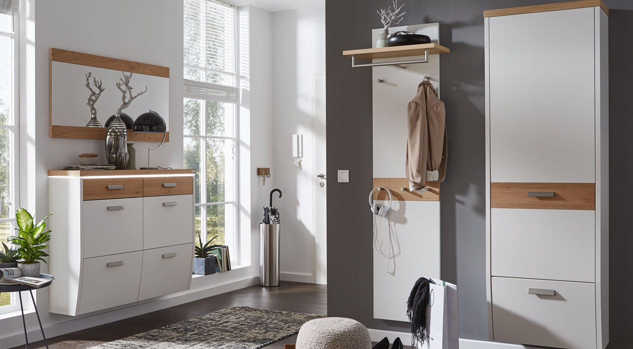 Heller Eingangsbereich mit weiß-holzfarbenen Möbeln, Spiegel, Garderobe, Deko und Pflanzen