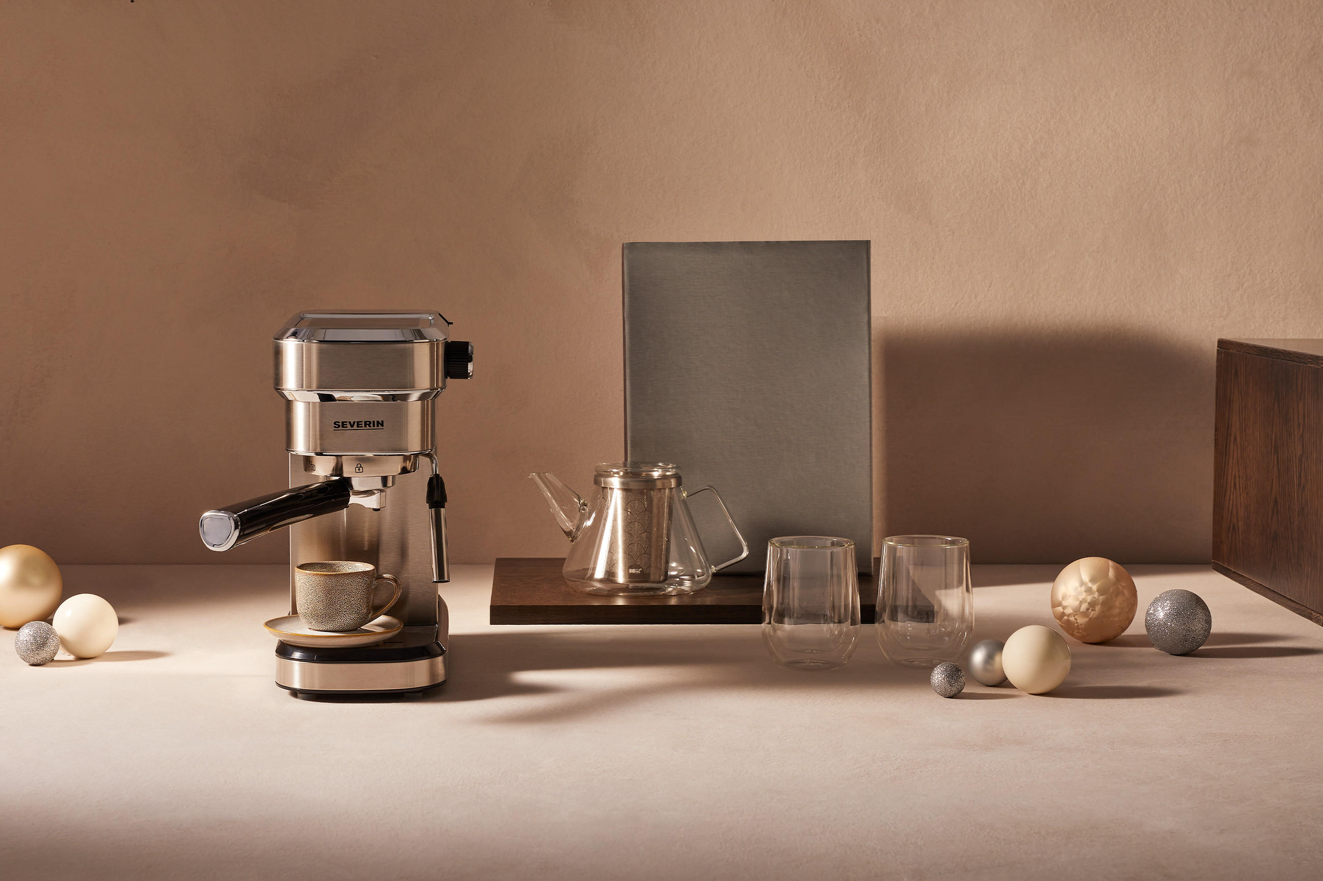 Kaffeemaschine und Kaffeekanne in weihnachtlicher Atmosphäre mit Christbaumkugeln