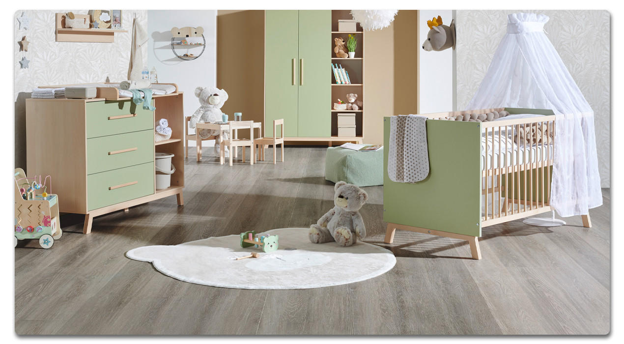 babyzimmer in grün mit babybett im vordergrund