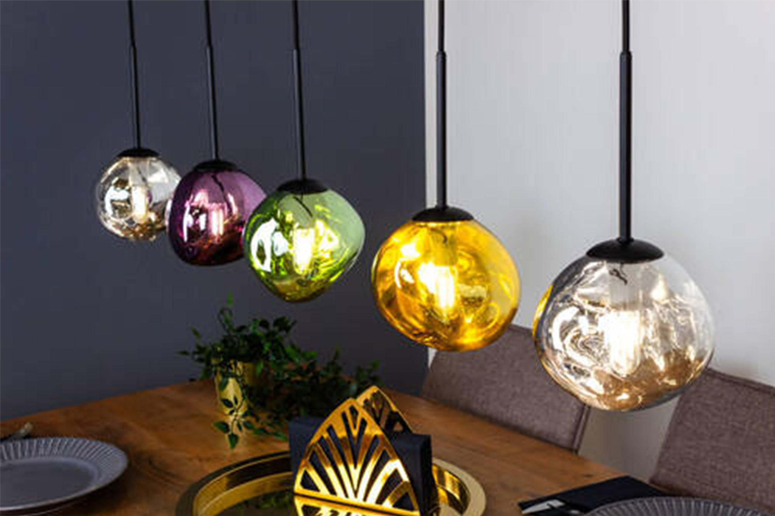 Essbereich mit fünf bunten Kugel-Pendelleuchten über einem Holztisch, gedeckt mit Tellern und dekorativer Mitte.