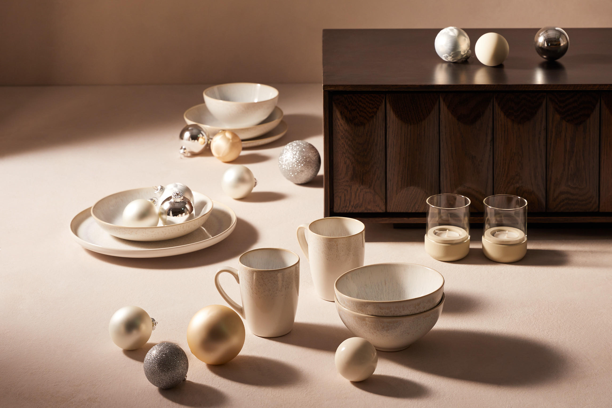 graues Geschrir in einer weihnachtlichen Atmosphäre mit Christbaumkugeln