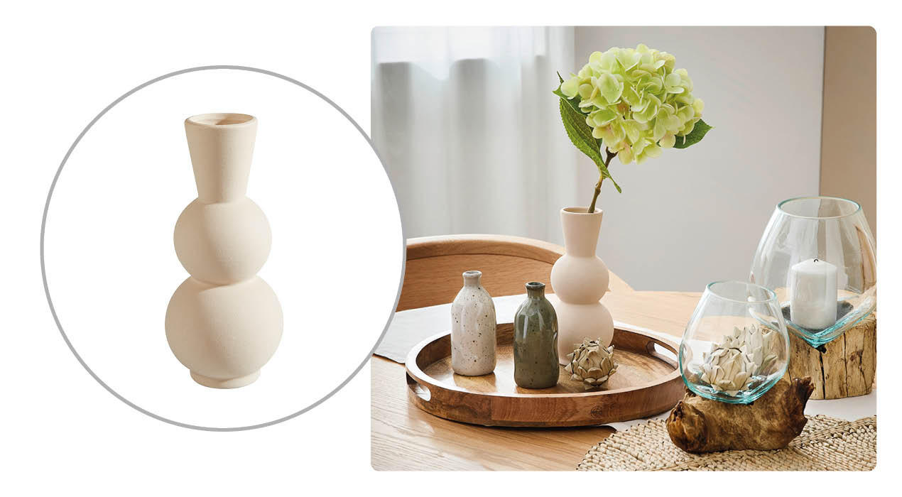 Helle, dreifach kugelförmige Deko-Vase in Beige sowie Wohnszene mit derselben Vase auf einem runden Holztablett, kombiniert mit kleinen Keramikvasen, Glasgefäßen mit Kerzen und einer grünen Hortensienblüte.
