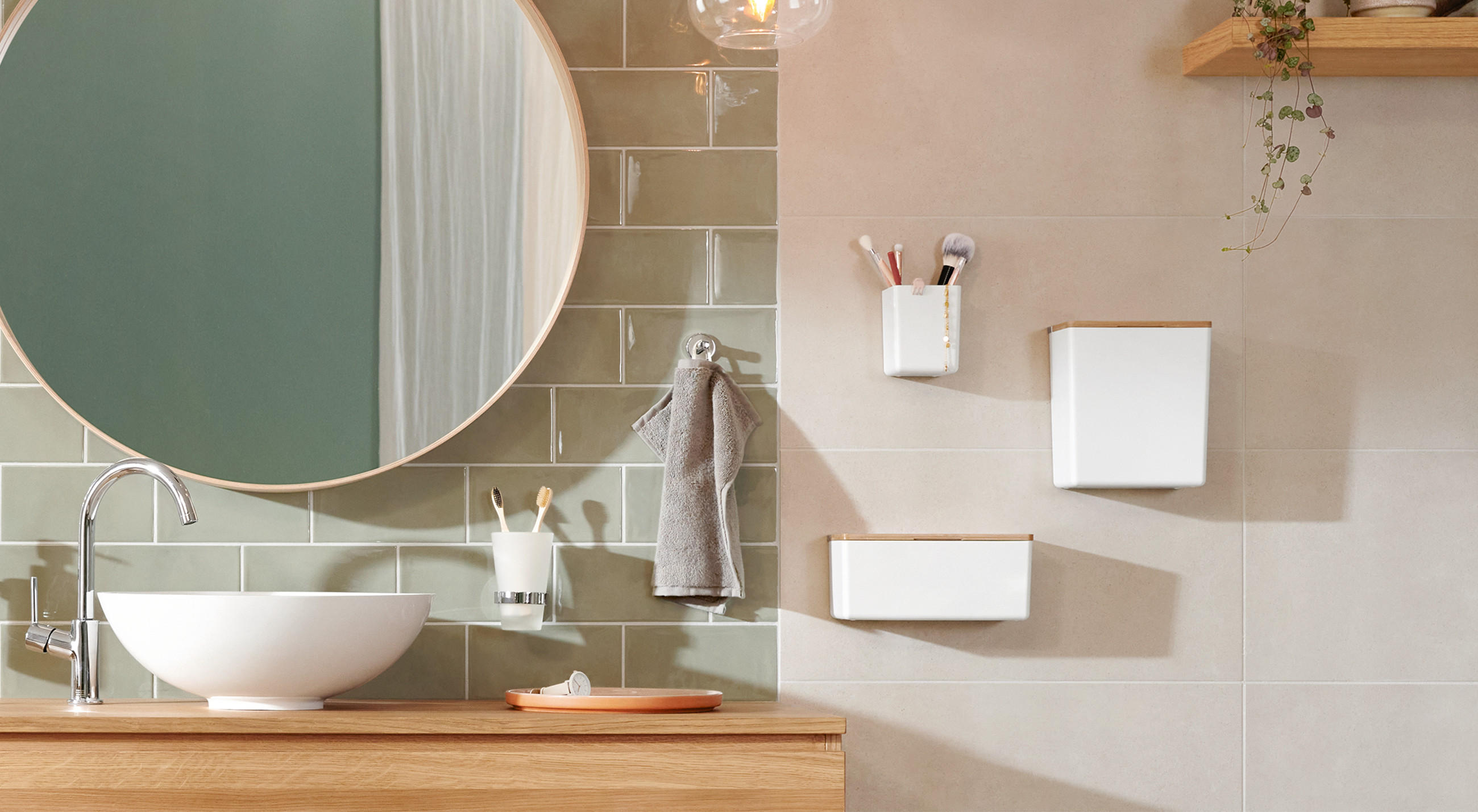 Innenansicht eines Badezimmers mit Waschbecken, Spiegel und Aufbewahrungsboxen an der Wand