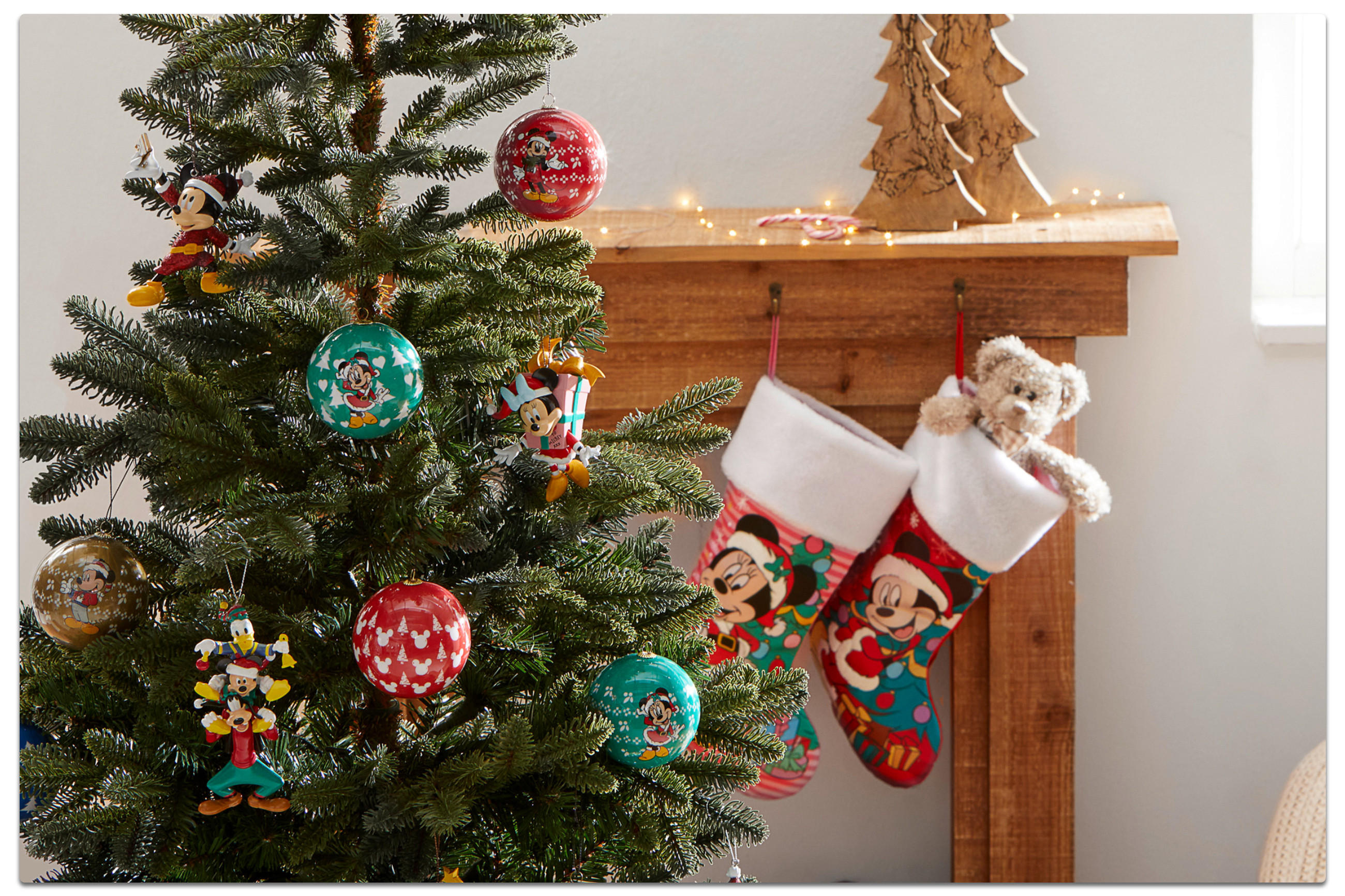 Festlicher Weihnachtsbaum mit Mickey Mouse-Dekorationen und bunten Strümpfen, ideal für die Weihnachtszeit