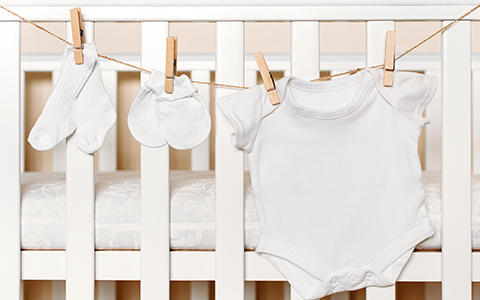 Weiße Babykleidung auf Wäscheleine