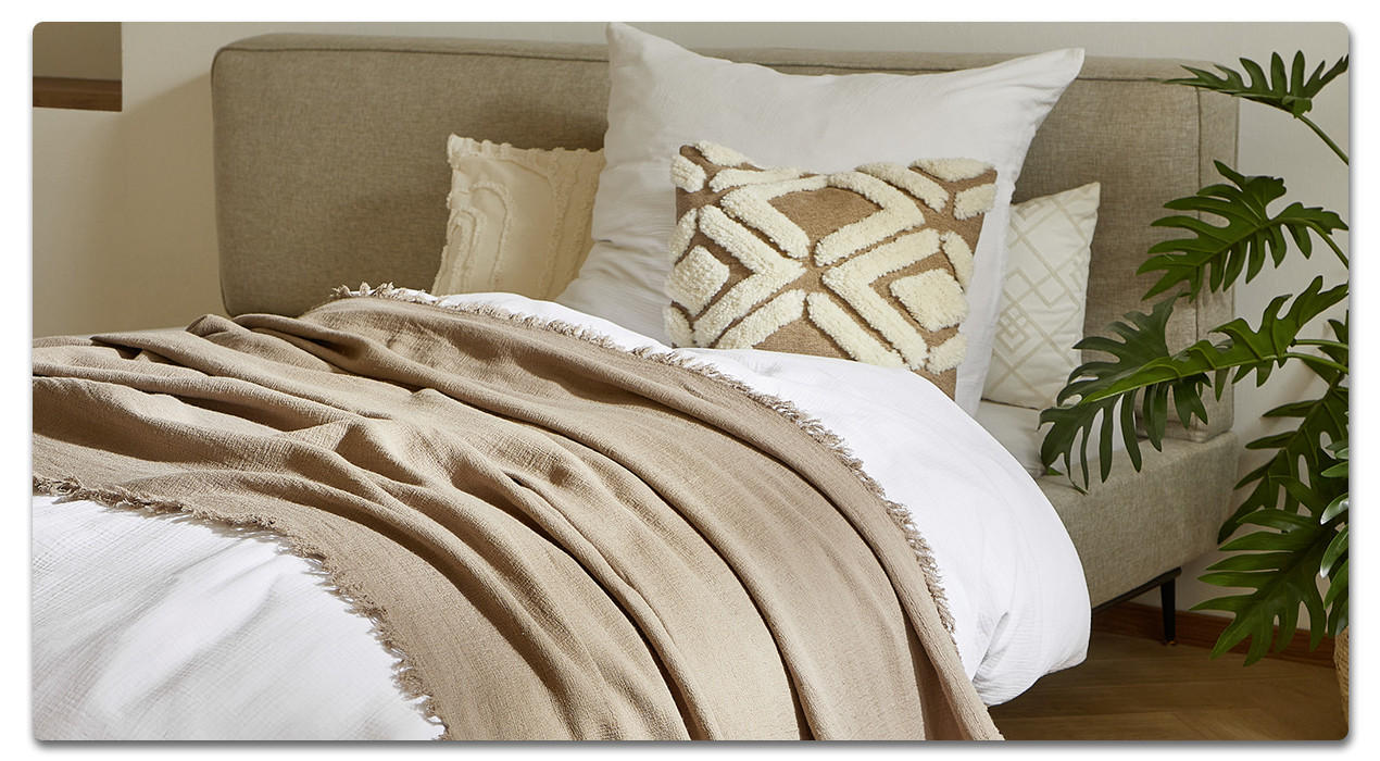 Bett mit weißer Bettwäsche und Beigen Accessoires