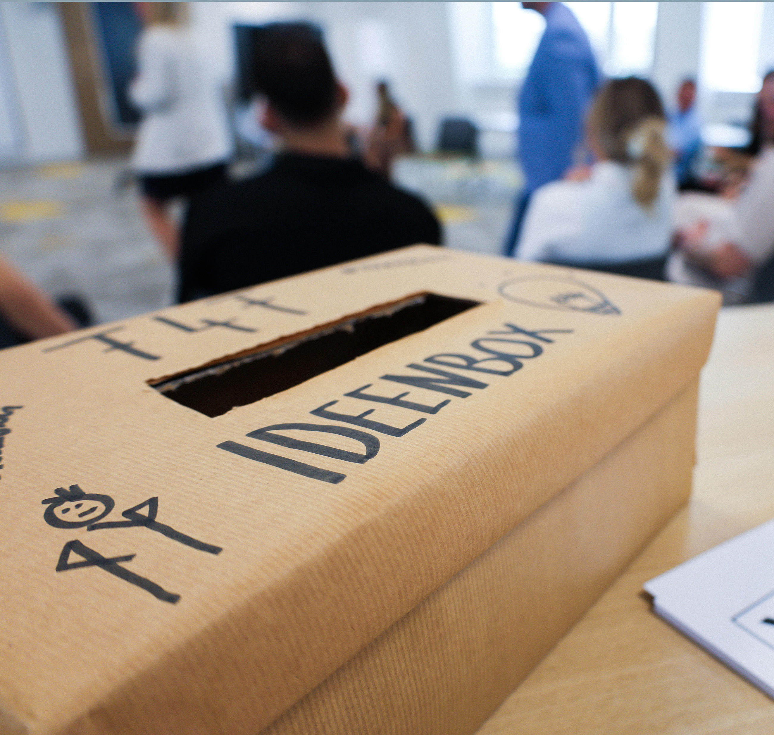 Ideenbox einem Raum mit XXXLutz Mitarbeitenden.