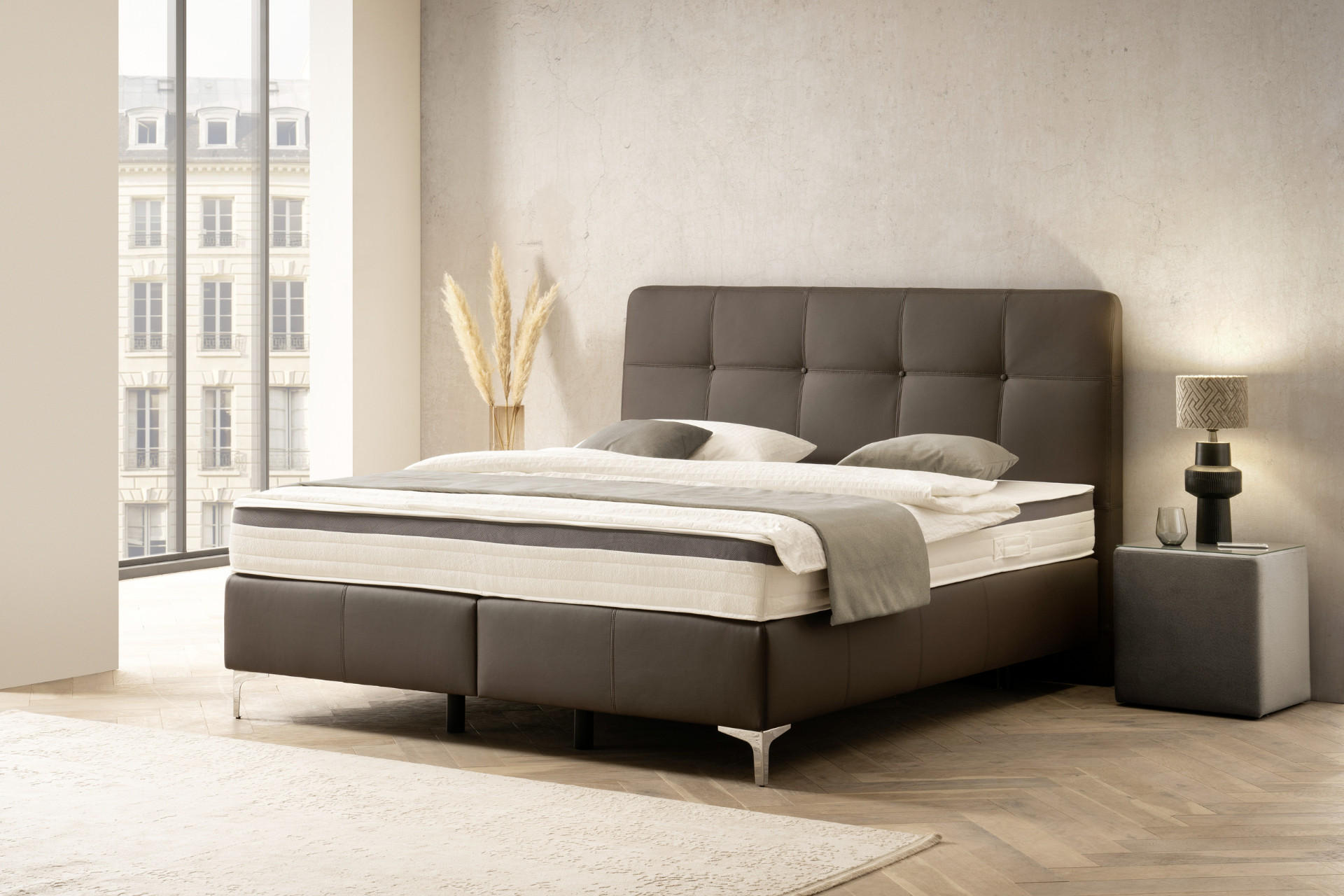 Modernes Schlafzimmer mit einem dunkelgrauen Bett und hellen Accessoires