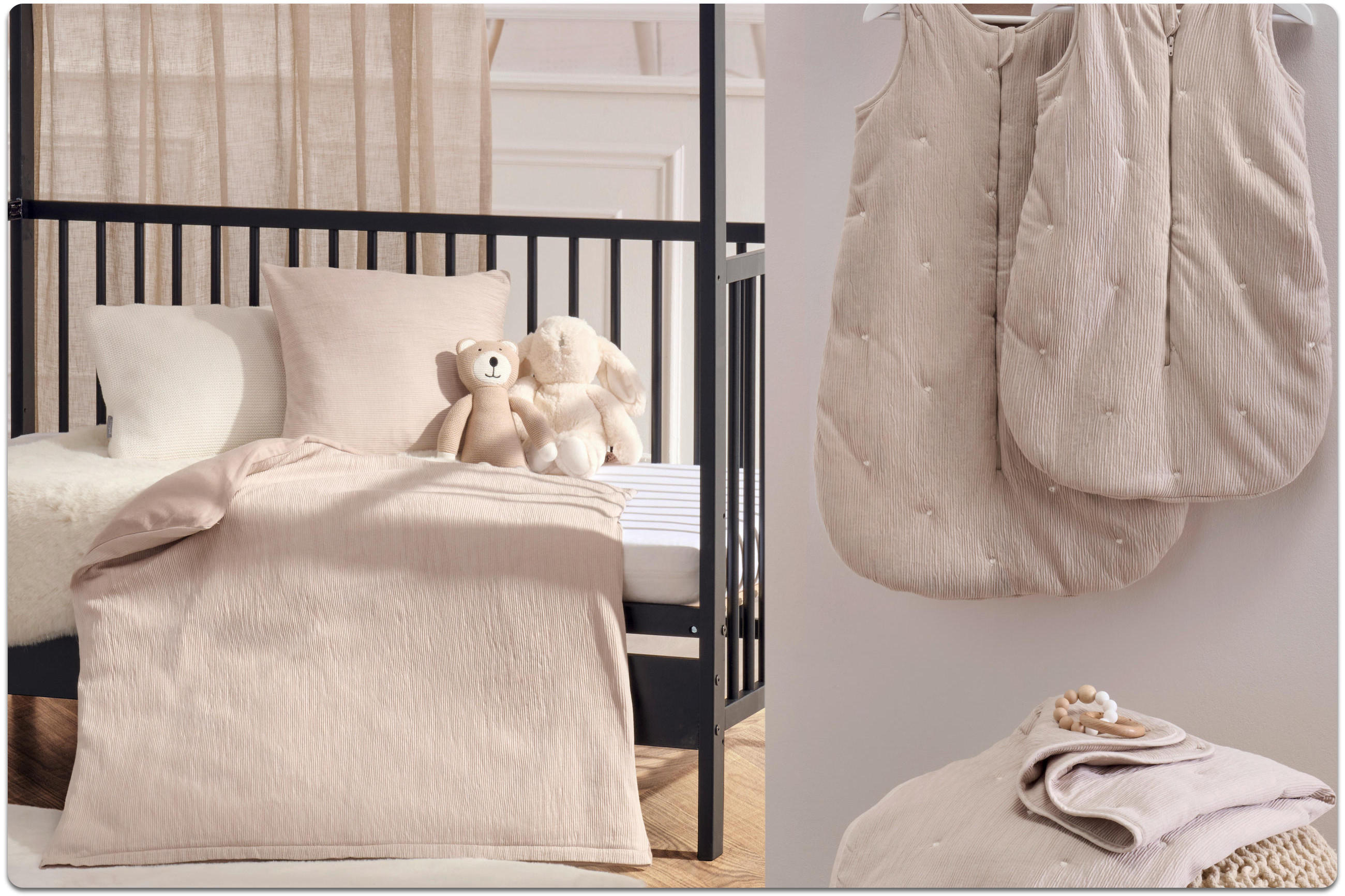 Ein Babybett mit schwarzen Metallstäben befindet sich links im Hintergrund des Bildes. Darauf liegen zwei Kuscheltiere in beige und creme sowie zwei Kissen und eine Decke in beige. Im Vordergrund hängen zwei Baby-Schlafsäcke in beige auf Kleiderbügeln.