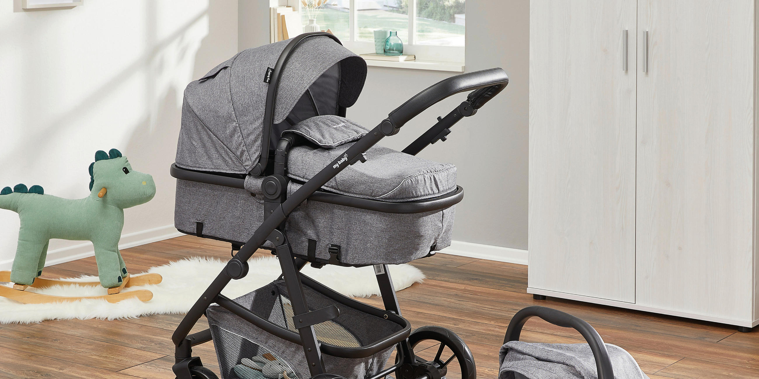 Kinderwagen mit Babyschale in einem Kinderzimmer stehend