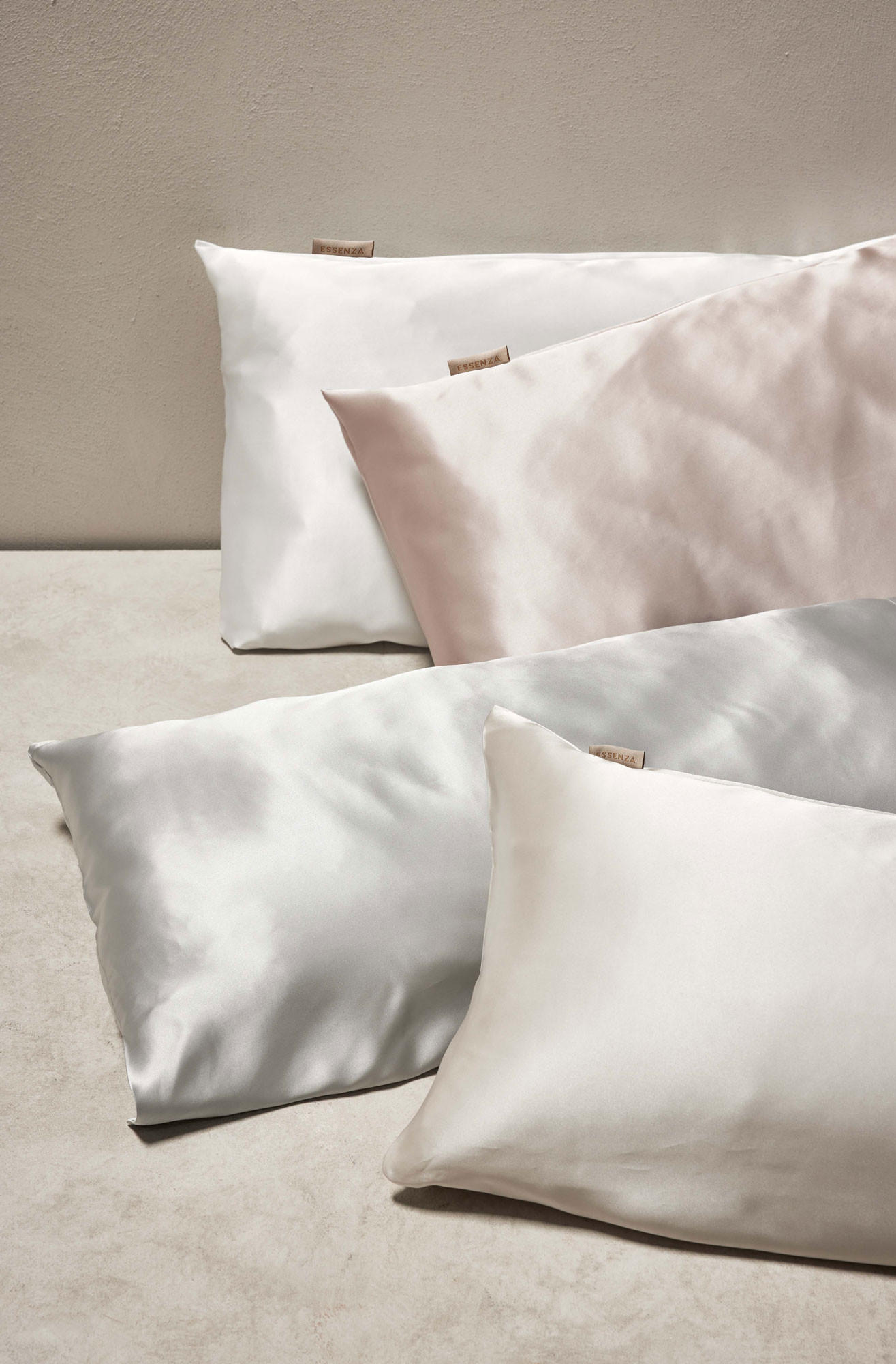 Tri blazine s satenskimi prevlekami na beli površini.