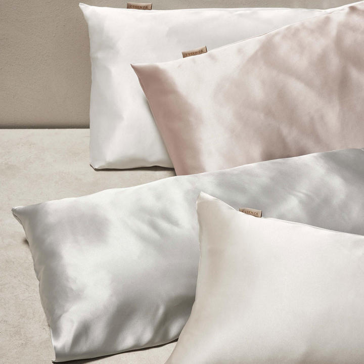 Tri blazine s satenskimi prevlekami na beli površini.