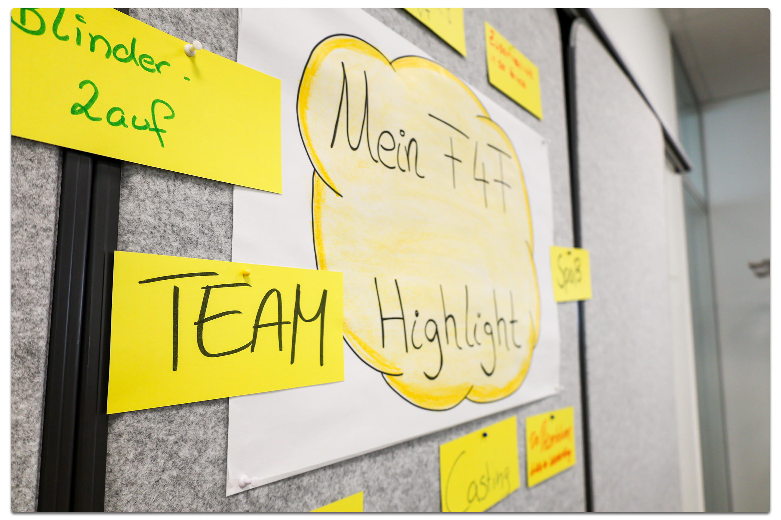 Pinnwand mit gelbem Zettelkreis um ein Blatt mit der Aufschrift ‚Mein Fit 4 Future Highlight‘.