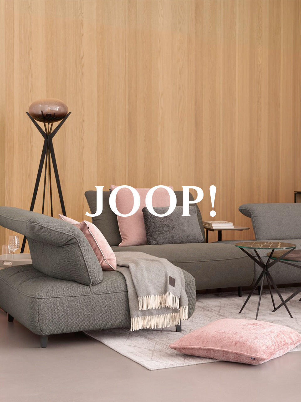 JOOP couch in grau mit rosaner decke 