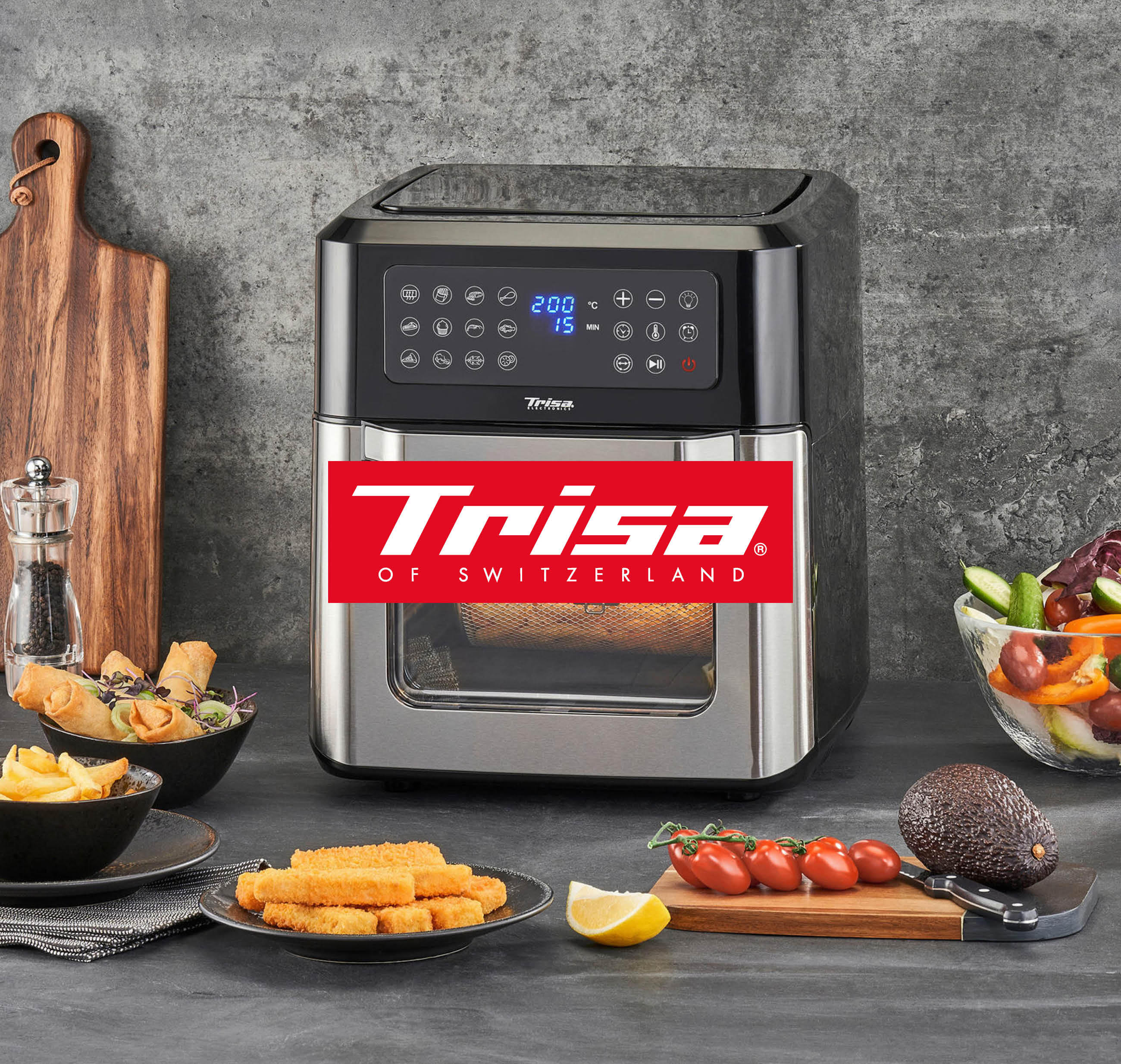 Eine Küche mit einem Trisa Airfryer und verschiedenen zubereiteten Speisen auf der Arbeitsfläche.