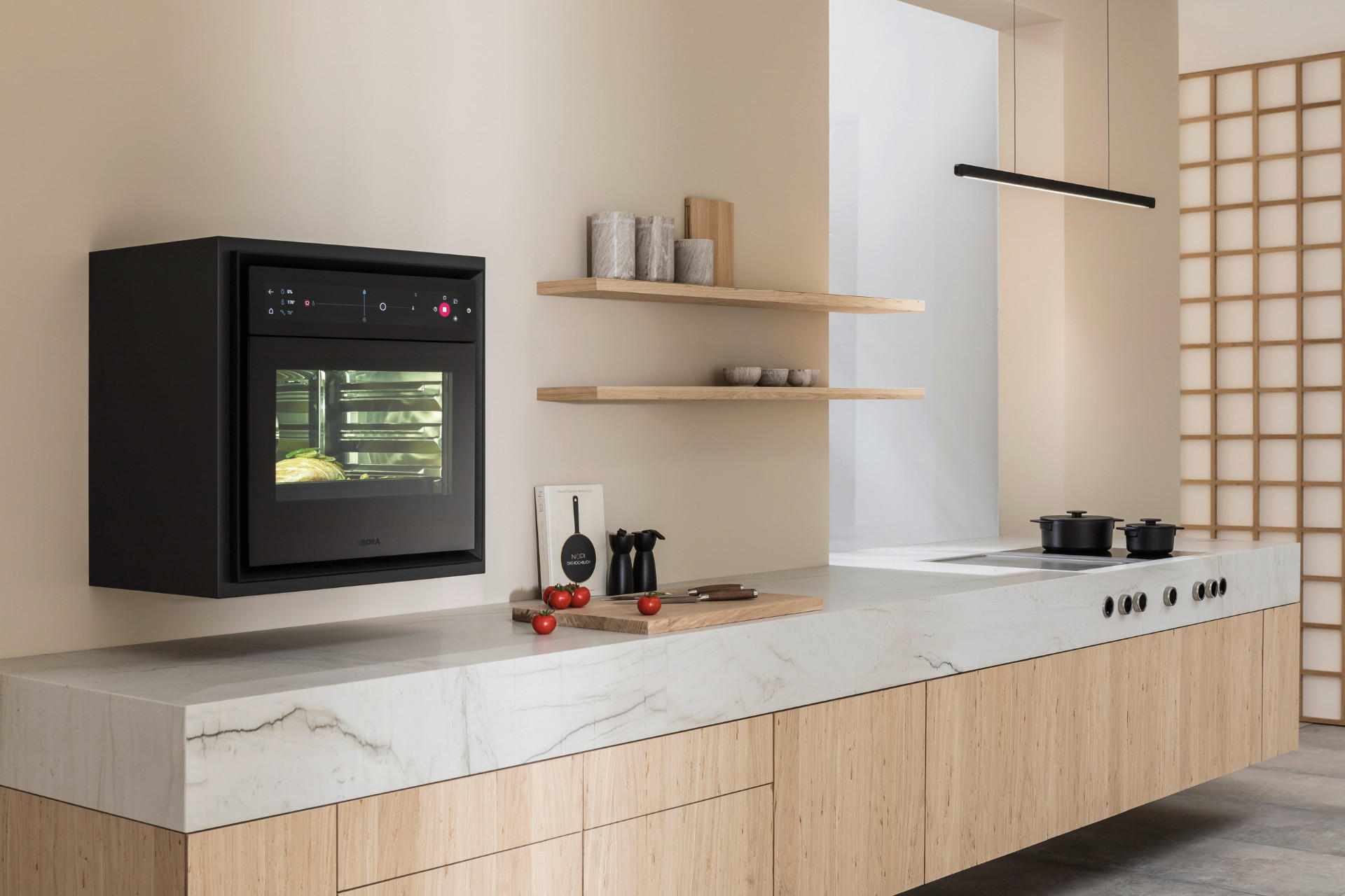 Eine helle Küche aus Holz und Marmor und ein BORA Backofen