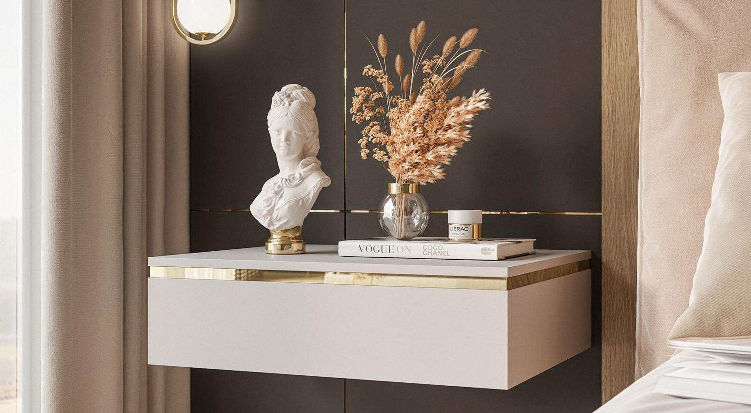 Freihängender Nachttisch in beige mit goldenem Akzent und Dekoration vor grauer Wand.