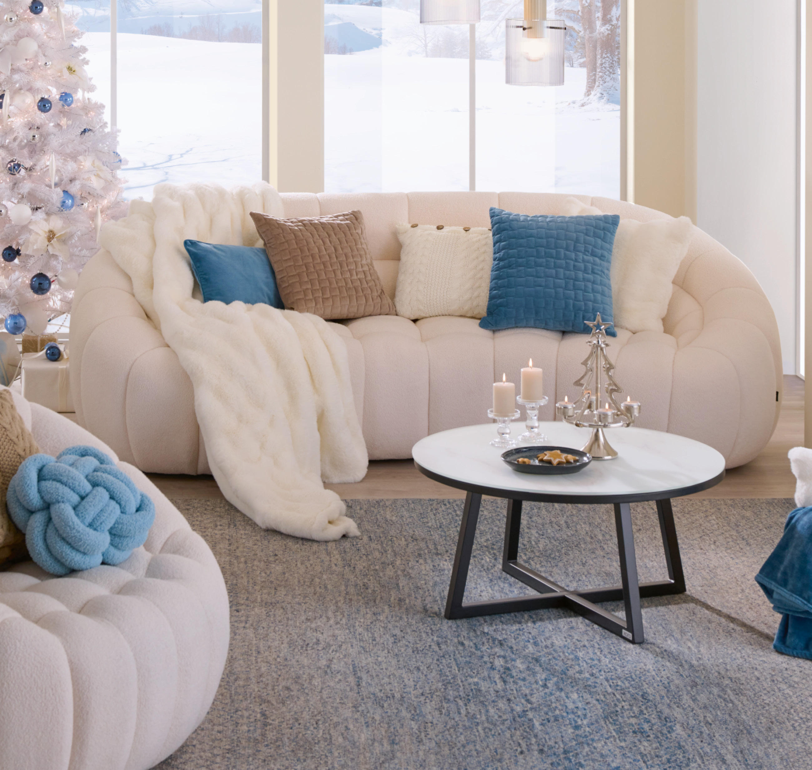 Weiße Couch mit blauen, weißen und braunen Heimtextilien