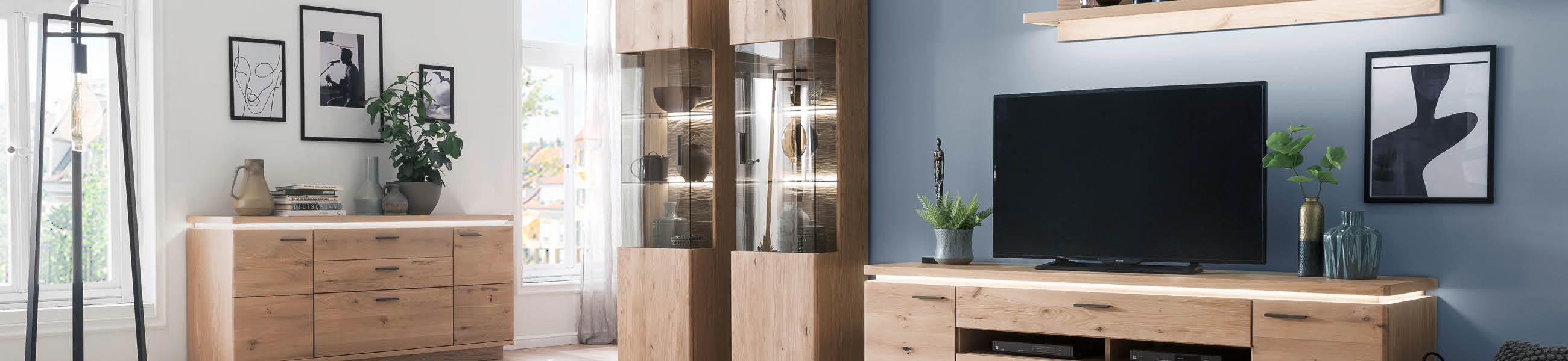 Ein Wohnzimmer mit einem Fernseher, einem Couchtisch und weiteren Möbeln, gemütlich und einladend eingerichtet.