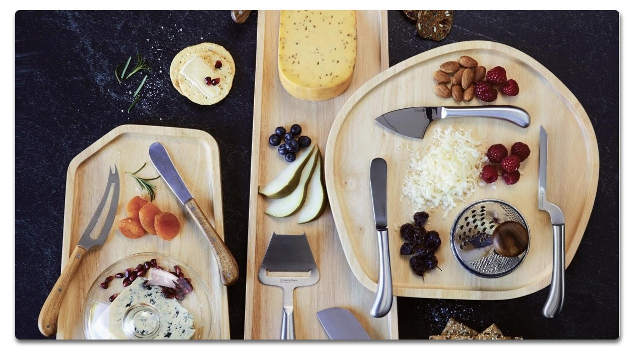 Käseplatten mit Besteck und Obst angerichtet