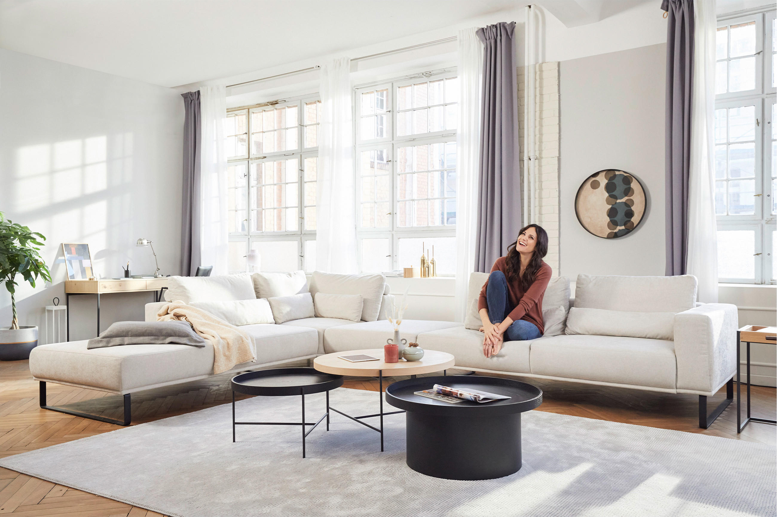 Eine Frau sitzt auf einer Couch in einem Wohnzimmer