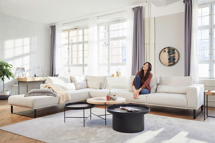 Eine Frau sitzt auf einer Couch in einem Wohnzimmer