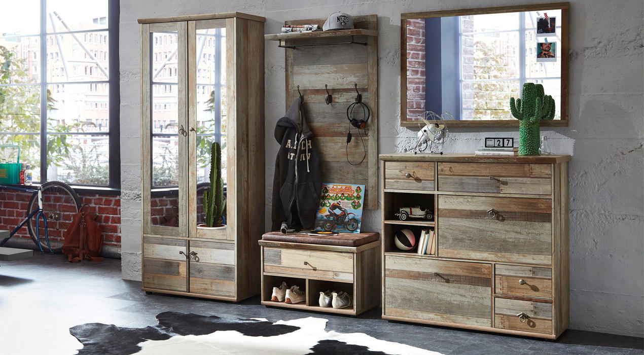 Rustikaler Raum mit Holzmöbeln, darunter eine Glasvitrine, eine Sitzbank mit Haken und eine Kommode mit Spiegel, dekoriert mit Kleidung, Büchern und Accessoires
