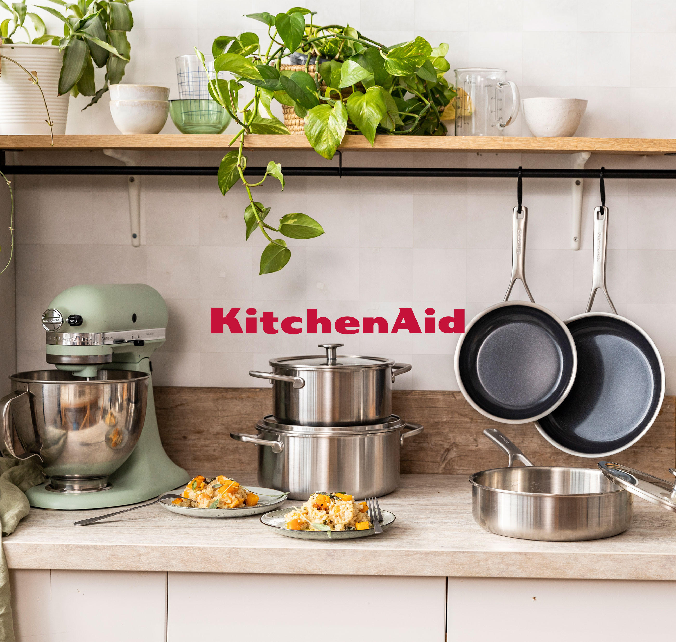 KitchenAid-Küchenware, darunter Mixer und Töpfe, präsentiert in einer hellen, einladenden Küche.